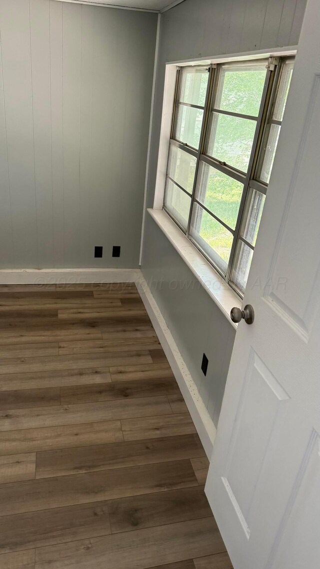 unfurnished room featuring dark wood-type flooring and baseboards