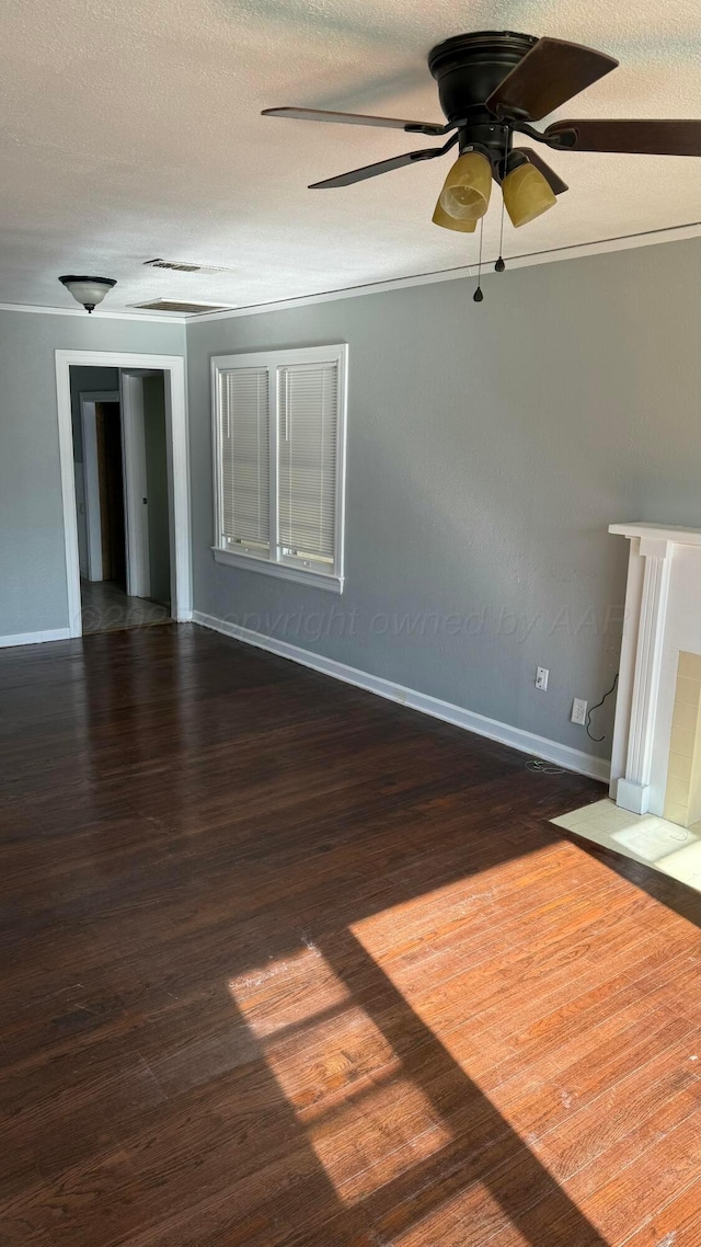 unfurnished room featuring baseboards, wood finished floors, ceiling fan, and a textured ceiling