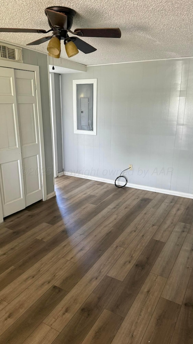 unfurnished bedroom featuring a textured ceiling, visible vents, dark wood-style flooring, and baseboards