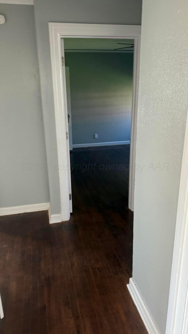 corridor featuring hardwood / wood-style flooring and baseboards