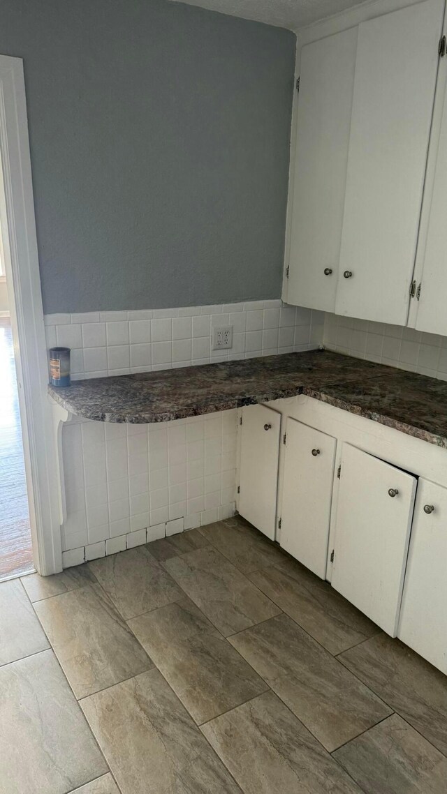 kitchen with white cabinets and dark countertops