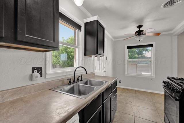 kitchen with black range with gas cooktop, a sink, dark cabinets, plenty of natural light, and crown molding