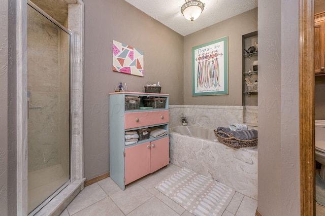 full bath with a stall shower, toilet, tile patterned floors, a garden tub, and a textured ceiling