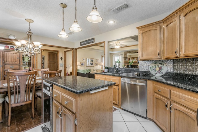 kitchen with a center island, tasteful backsplash, visible vents, a sink, and dishwasher