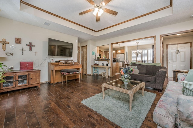 living room with a tray ceiling, wood-type flooring, and a textured ceiling