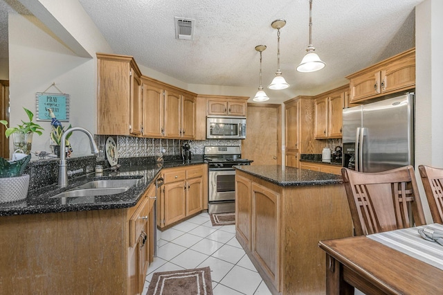 kitchen with visible vents, decorative backsplash, appliances with stainless steel finishes, light tile patterned flooring, and a sink