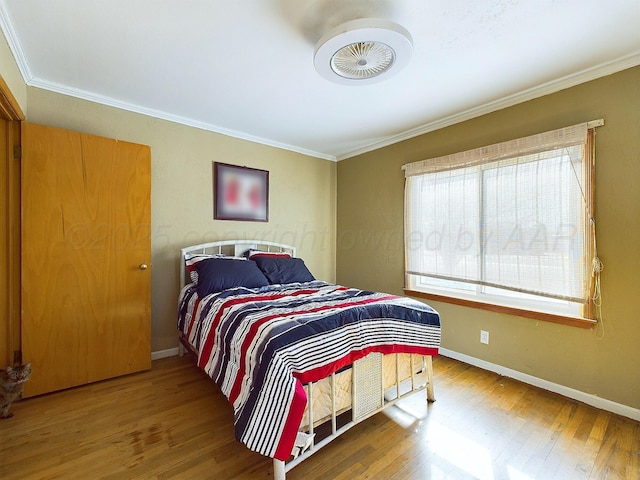 bedroom featuring hardwood / wood-style flooring and crown molding
