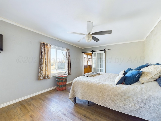 bedroom featuring crown molding, ceiling fan, wood-type flooring, and a barn door