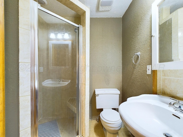 bathroom featuring tile patterned floors, toilet, a shower with shower door, and sink