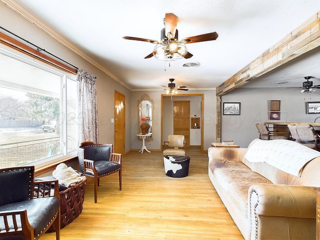 living room featuring crown molding, ceiling fan, and light wood-type flooring