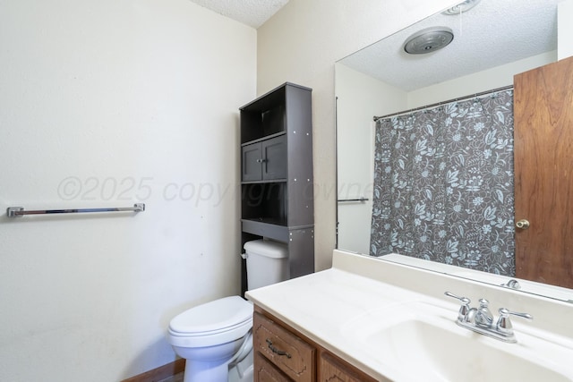 bathroom featuring curtained shower, toilet, vanity, and a textured ceiling