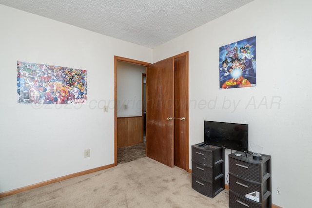 bedroom with light colored carpet and a textured ceiling