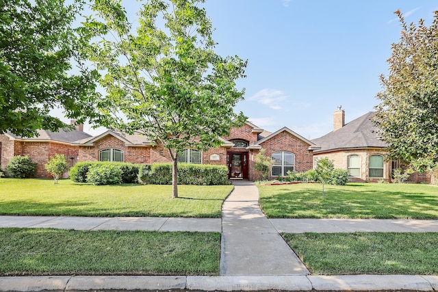 ranch-style home featuring a front lawn