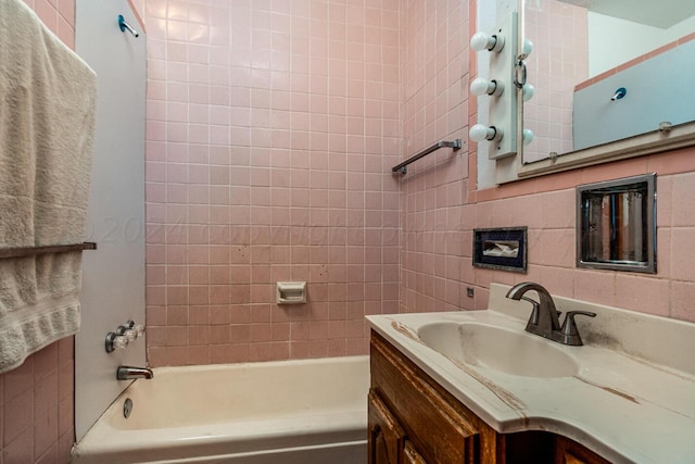 bathroom with tiled shower / bath and vanity