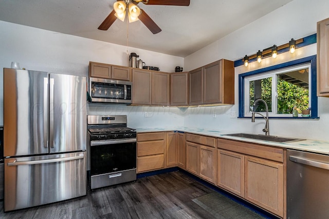 kitchen featuring tasteful backsplash, appliances with stainless steel finishes, dark hardwood / wood-style flooring, sink, and ceiling fan