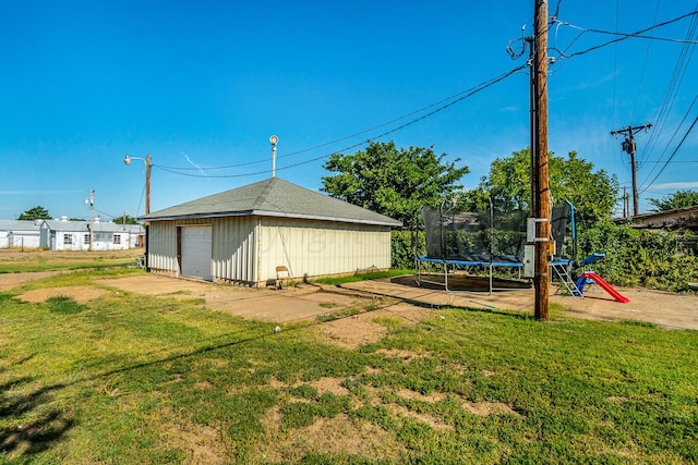 exterior space featuring an outbuilding, a garage, and a trampoline