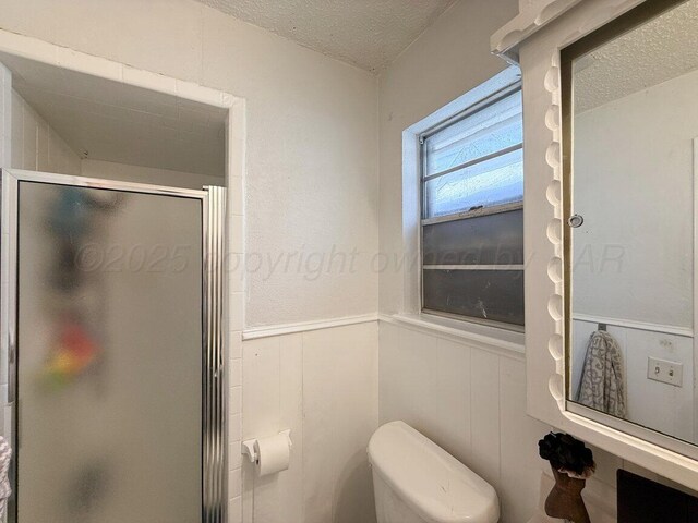 5216 Westway Trl, Amarillo, TX 79109 - full bathroom with a textured ceiling, a wainscoted wall, and a stall shower