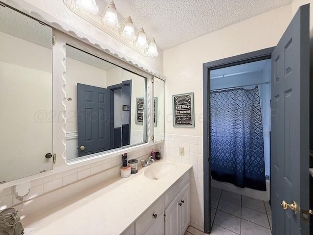 5216 Westway Trl, Amarillo, TX 79109 - full bath with a textured ceiling, vanity, tile patterned flooring, tile walls, and a wainscoted wall