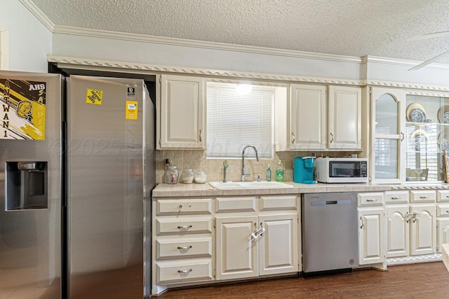 5216 Westway Trl, Amarillo, TX 79109 - kitchen with stainless steel appliances, ornamental molding, a textured ceiling, dark wood-type flooring, and tasteful backsplash