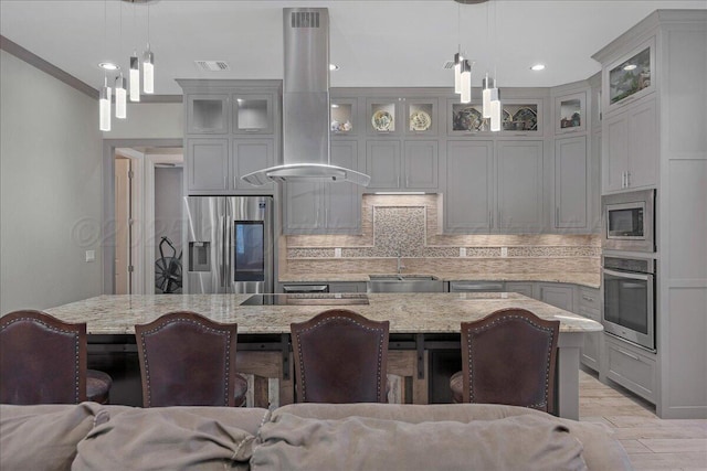 8205 S Liberty Cir, Amarillo, TX 79119 - kitchen with stainless steel appliances, island range hood, decorative backsplash, a kitchen breakfast bar, and light stone countertops