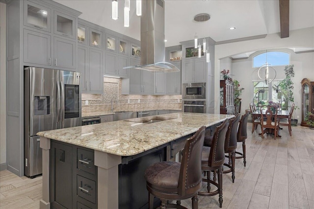 8205 S Liberty Cir, Amarillo, TX 79119 - kitchen featuring appliances with stainless steel finishes, island range hood, a kitchen island, tasteful backsplash, and light stone countertops