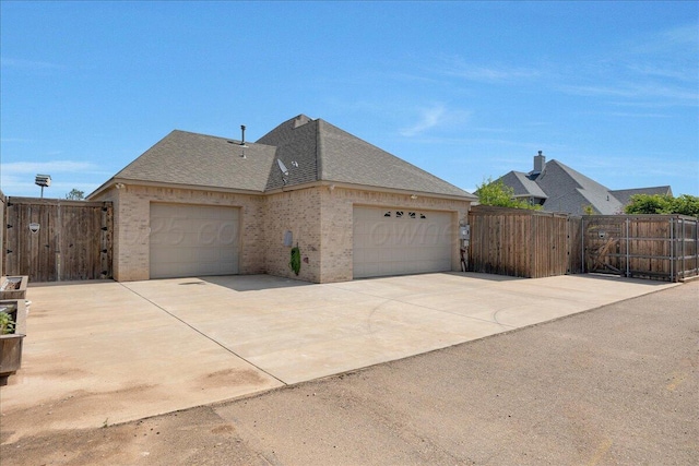 8205 S Liberty Cir, Amarillo, TX 79119 - view of side of home with brick siding, a shingled roof, and concrete driveway