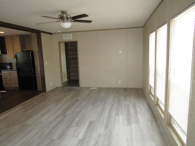 unfurnished living room with light hardwood / wood-style floors, ceiling fan, and crown molding