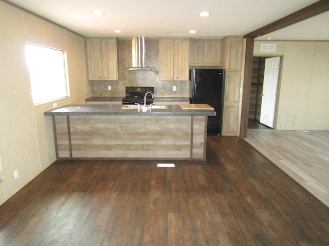 kitchen with light brown cabinets, wall chimney range hood, black appliances, and dark hardwood / wood-style flooring