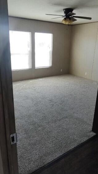 spare room with ceiling fan and carpet floors