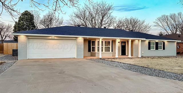 single story home featuring driveway, roof with shingles, an attached garage, fence, and brick siding