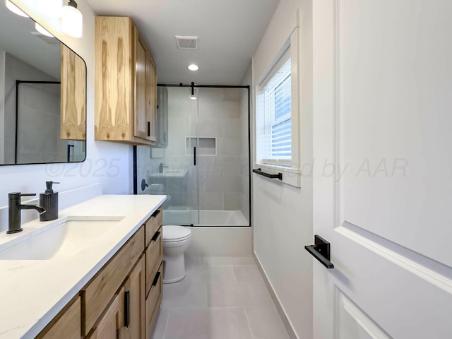 bathroom with visible vents, toilet, enclosed tub / shower combo, tile patterned floors, and vanity