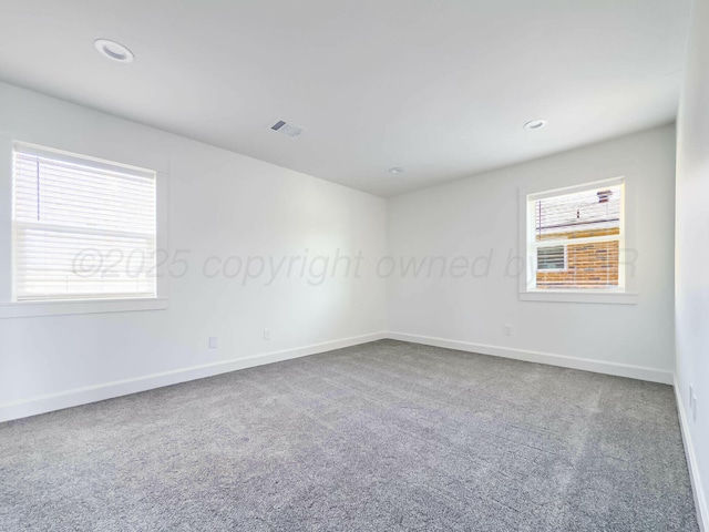 spare room featuring carpet, visible vents, baseboards, and recessed lighting