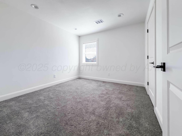 unfurnished room with carpet, visible vents, and baseboards