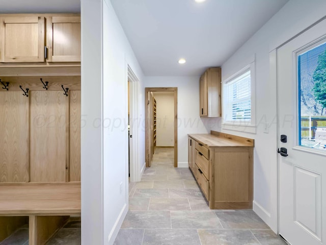 mudroom featuring stone finish flooring, baseboards, and recessed lighting