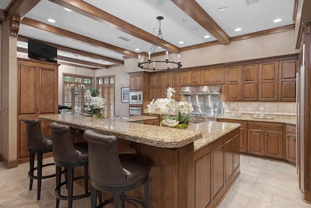 3506 Van Winkle Dr, Amarillo, TX 79121 - kitchen featuring a spacious island, tasteful backsplash, beamed ceiling, under cabinet range hood, and appliances with stainless steel finishes
