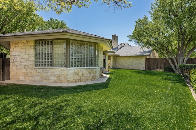 3506 Van Winkle Dr, Amarillo, TX 79121 - view of side of home featuring a lawn, a chimney, fence, and stone siding