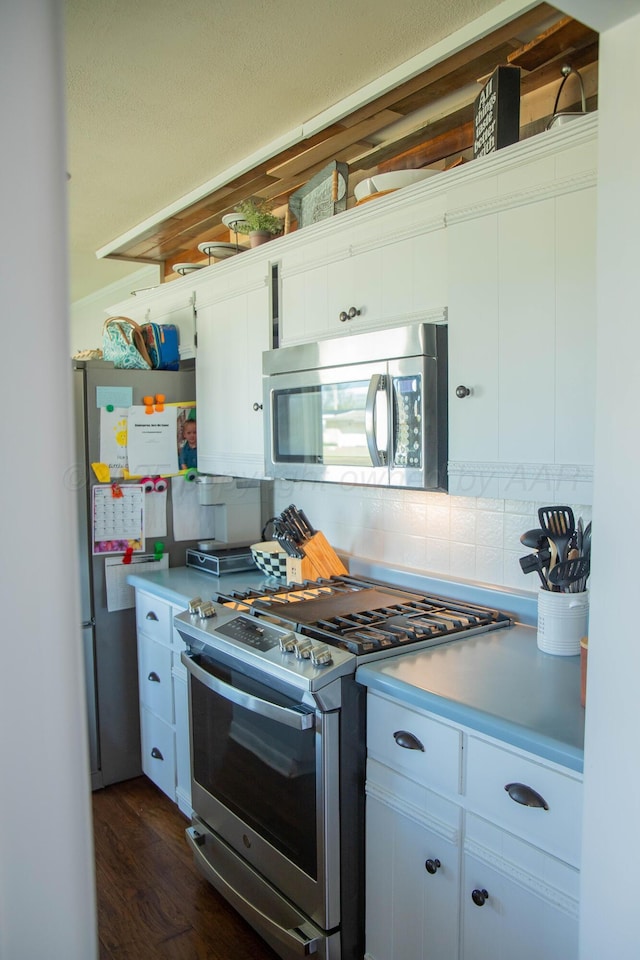 1418 Oak Ave, Panhandle, TX 79068 - kitchen with stainless steel appliances, tasteful backsplash, dark wood-type flooring, and light countertops
