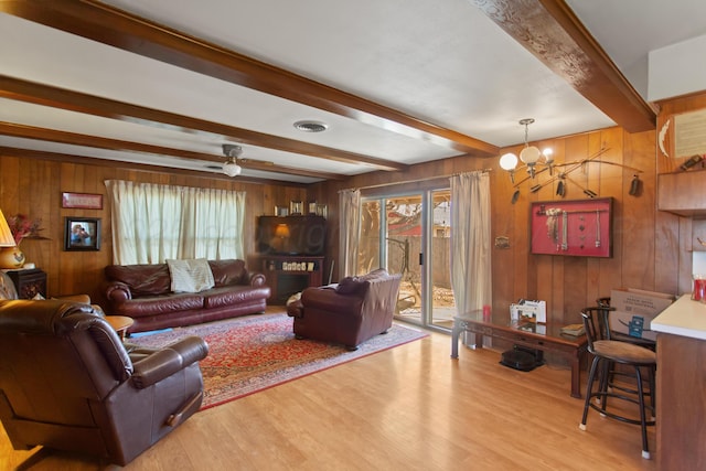 living room with light wood-style floors, plenty of natural light, visible vents, and beam ceiling