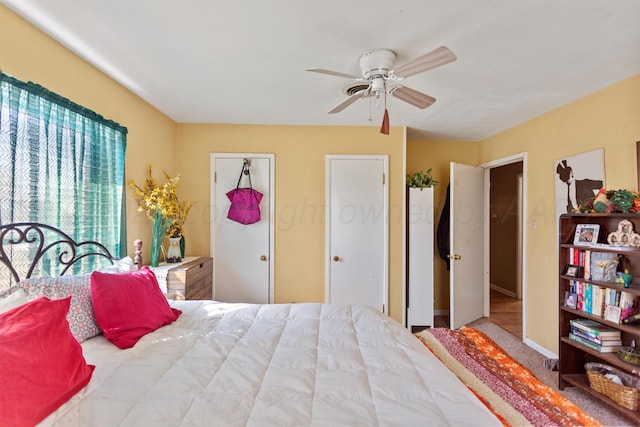 carpeted bedroom with a ceiling fan and baseboards