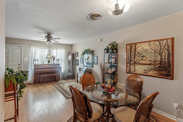 dining area with visible vents, ceiling fan, light wood-style flooring, and baseboards