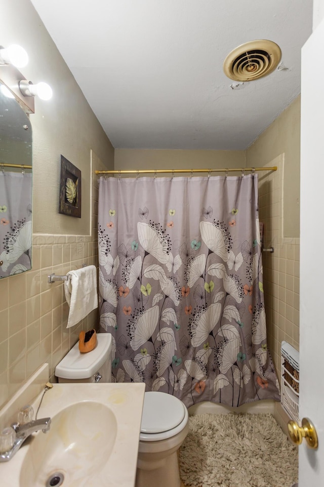 full bathroom with toilet, curtained shower, visible vents, and tile walls