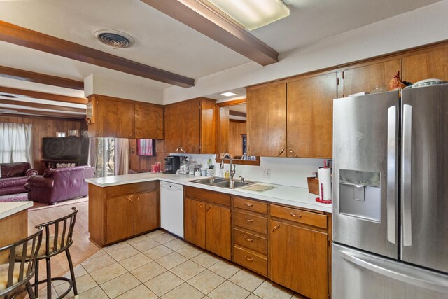 kitchen featuring visible vents, white dishwasher, light countertops, stainless steel refrigerator with ice dispenser, and a sink