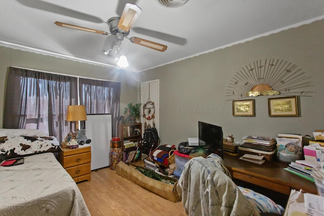 bedroom with ceiling fan, crown molding, visible vents, and light wood-style floors