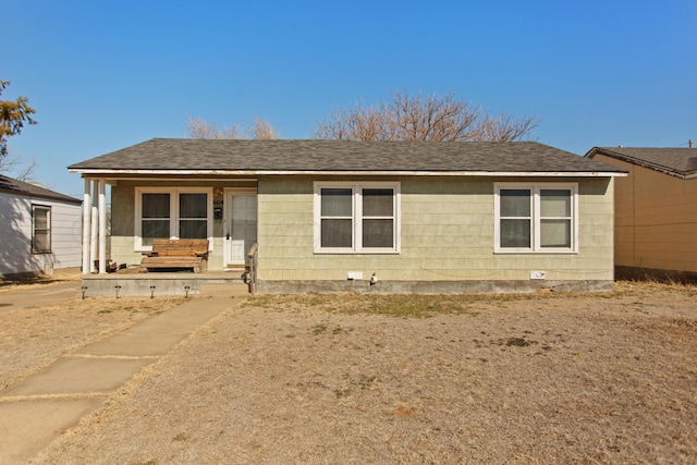 ranch-style home featuring a shingled roof and covered porch