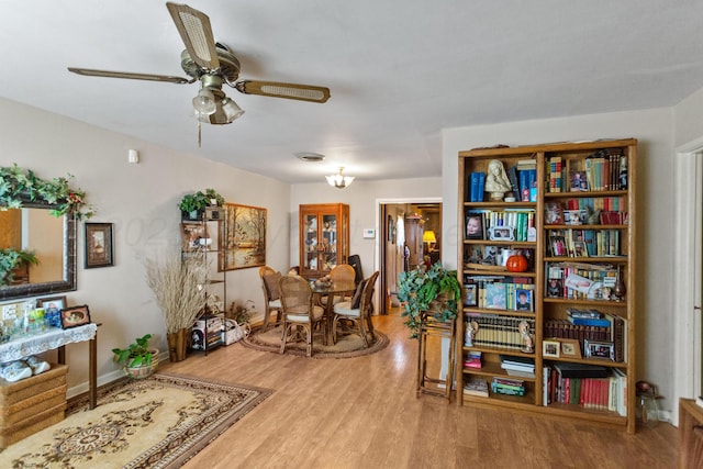 sitting room with ceiling fan and wood finished floors