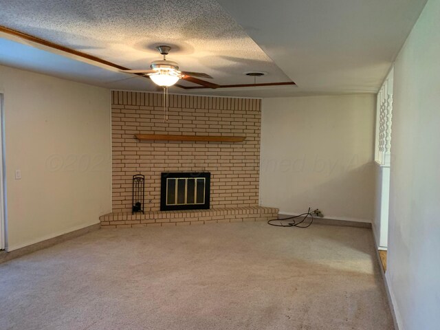 6812 Blacksmith Ln, Amarillo, TX 79109 - unfurnished living room featuring ceiling fan, carpet, a fireplace, a textured ceiling, and a raised ceiling