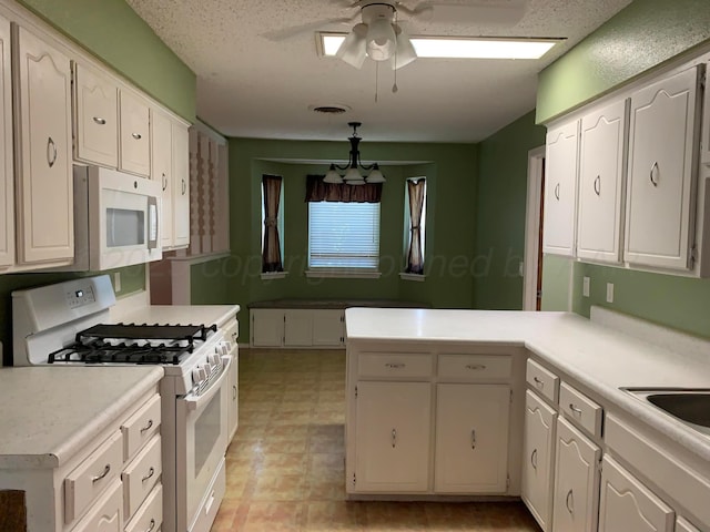 6812 Blacksmith Ln, Amarillo, TX 79109 - kitchen with white appliances, a peninsula, a ceiling fan, light countertops, and white cabinets