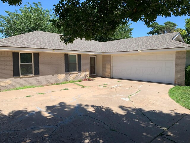 6812 Blacksmith Ln, Amarillo, TX 79109 - ranch-style house featuring brick siding, driveway, an attached garage, and roof with shingles