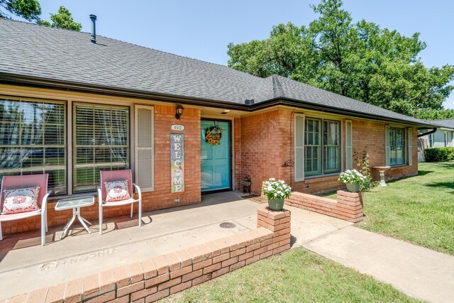 4512 Gem Lake Rd, Amarillo, TX 79106 - doorway to property with a shingled roof, brick siding, and a yard