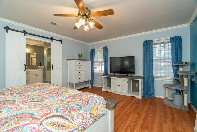 4512 Gem Lake Rd, Amarillo, TX 79106 - bedroom featuring a barn door, wood finished floors, ornamental molding, connected bathroom, and a ceiling fan